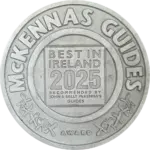 A silver medallion featuring the words "McKenna's Guides" around the edge, and "Best in Ireland 2025 Recommended by John & Sally McKenna's Guides Award" in the center.
