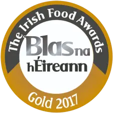 A circular gold and white badge with text: "The Irish Food Awards," "Blas na hÉireann," and "Gold 2017.