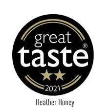 A black circular badge with gold lines framing the words "great taste" in white, two gold stars below, and "2021" at the bottom.